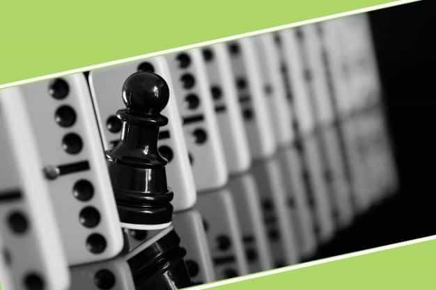 שורה של צלחות דומינו וביניהן כלי שחמט אחד המייצג עוסק מורשה מול עוסק פטור