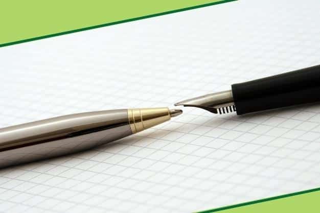 שני עטים מסוגים שונים מונחים על דף מחברת אחד מול השני המייצגים ההבדל בין יועץ מס לרואה חשבון